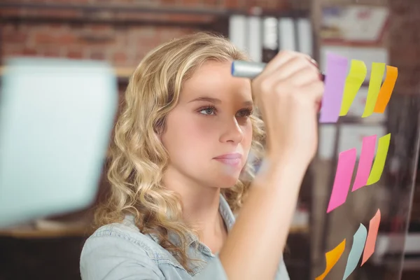 Creative businesswoman writing on sticky notes — Stock Photo, Image