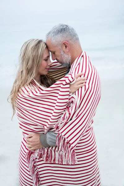 Casal abraçando enquanto envolto em toalha de praia — Fotografia de Stock