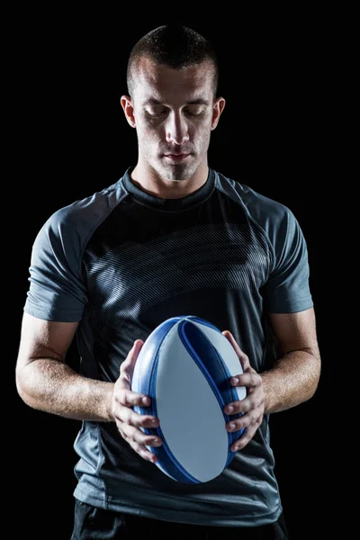 Jogador de rugby pensativo segurando bola — Fotografia de Stock