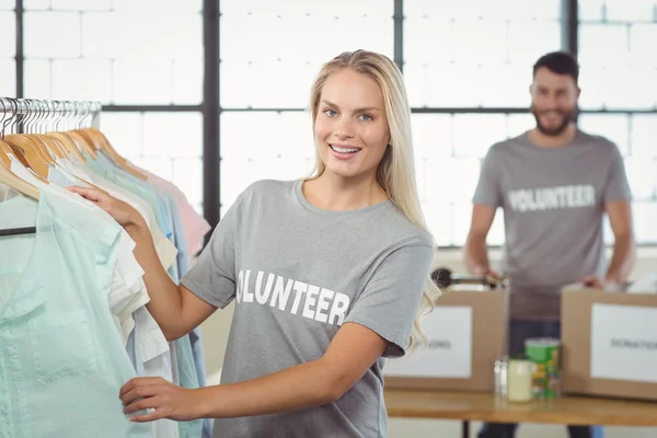 Voluntario eligiendo ropa para la donación — Foto de Stock