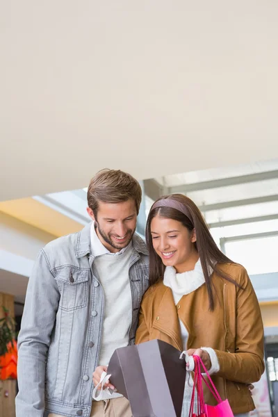 Casal olhando para sacos de compras — Fotografia de Stock