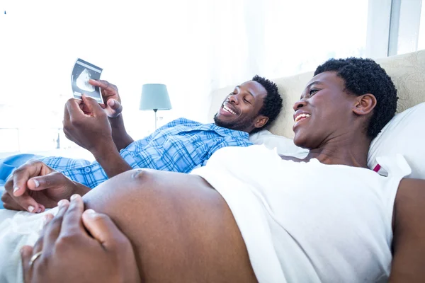 Man showing ultrasound scan to woman — Stock Photo, Image