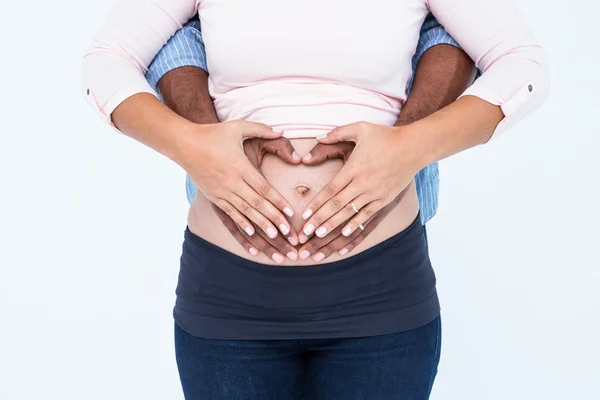 Casal fazendo forma de coração na barriga — Fotografia de Stock