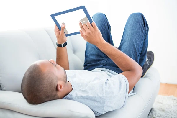 Hombre usando tableta ordenador en el sofá — Foto de Stock