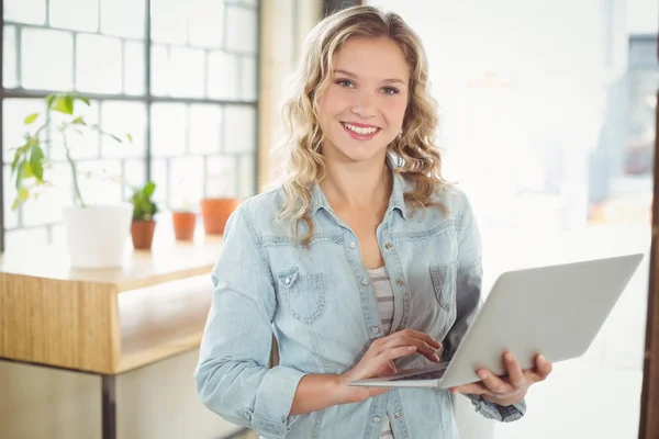 Leende kvinna anläggning laptop — Stockfoto