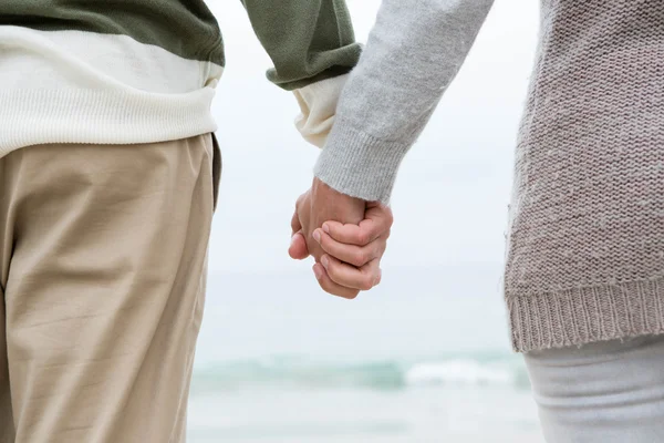 Paar hält Händchen am Strand — Stockfoto