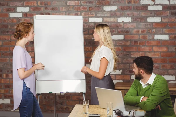 Colegas discutiendo sobre pizarra blanca en la oficina — Foto de Stock