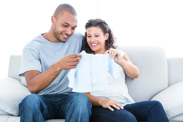 Casal olhando para roupas de bebê — Fotografia de Stock