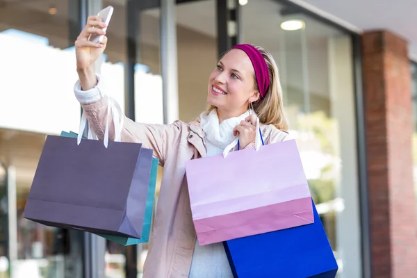 Frau mit Einkaufstüten macht Selfie — Stockfoto