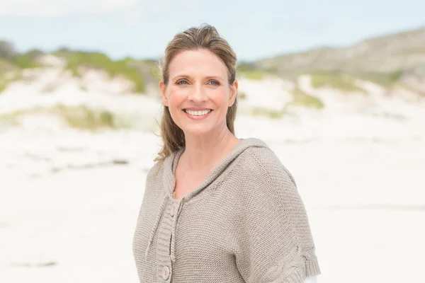 Femme souriante debout sur le sable — Photo