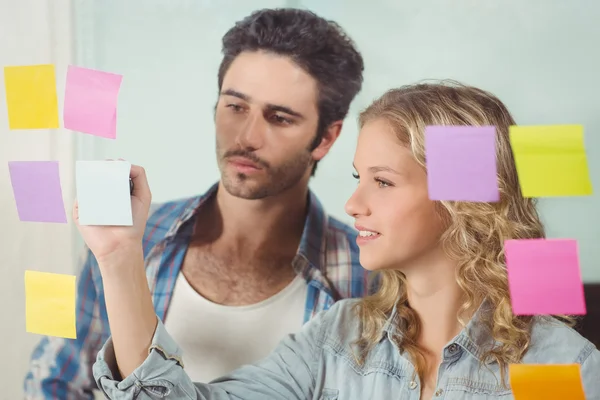 Uomo guardando donna che scrive su note — Foto Stock