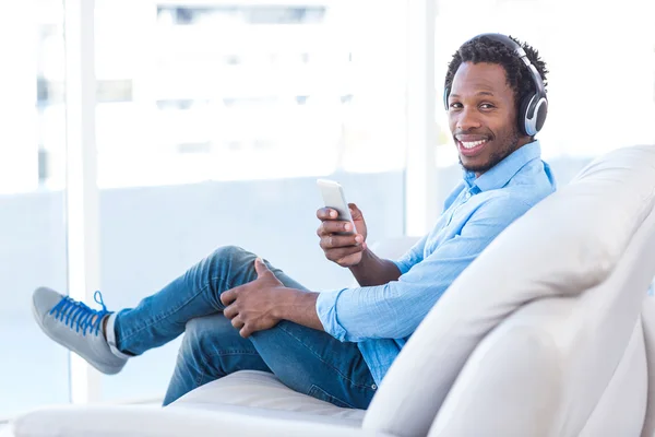 Uomo sorridente che ascolta musica — Foto Stock