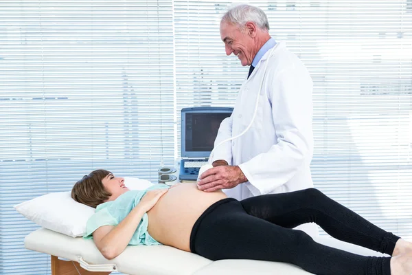 Medico che mostra il monitor a ultrasuoni alla donna — Foto Stock