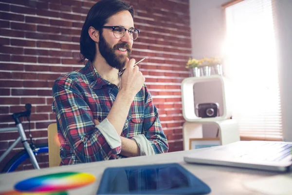 Creative businessman with hand on chin — Stock Photo, Image