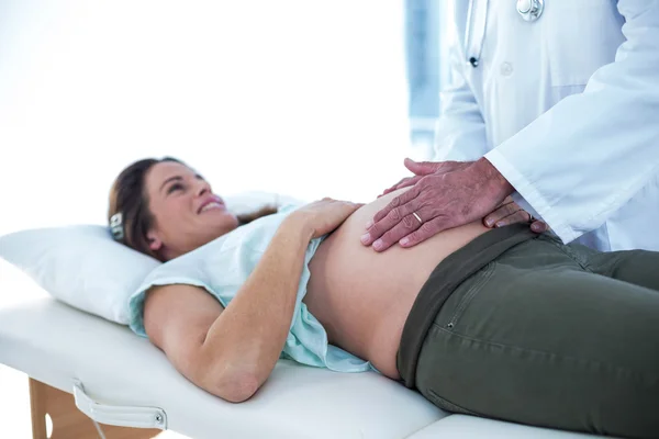 Γιατρός εξετάζει χαμογελώντας έγκυο γυναίκα — Φωτογραφία Αρχείου