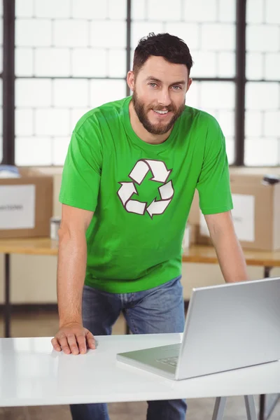 Άνθρωπος στην ανακύκλωση tshirt σύμβολο που εργάζονται στο lap-top — Φωτογραφία Αρχείου
