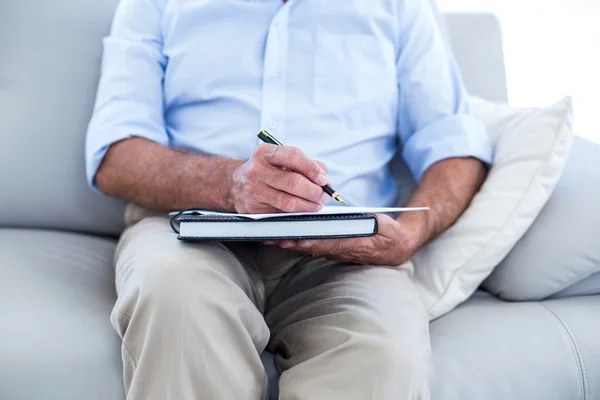 Empresario escribiendo mientras está sentado en el sofá — Foto de Stock