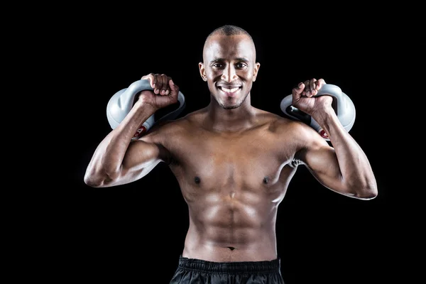 Homem muscular exercitando com kettlebells — Fotografia de Stock