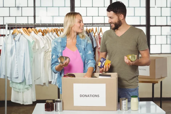 Colleagues discussing while separating products — Stock Photo, Image