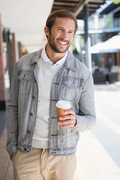 Smiling man holding a cup of coffee — Stock Photo, Image