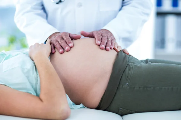 Hamile kadın mide inceleyerek doktor — Stok fotoğraf