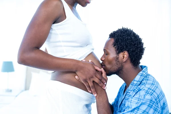 Affectionate man kissing belly of pregnant wife — Stock Photo, Image