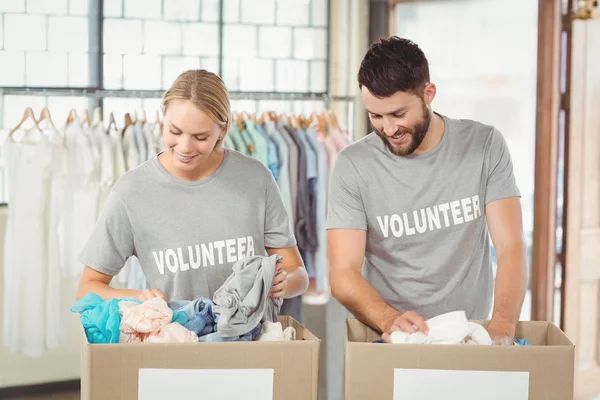 Добровольцы разделяют одежду для пожертвований — стоковое фото