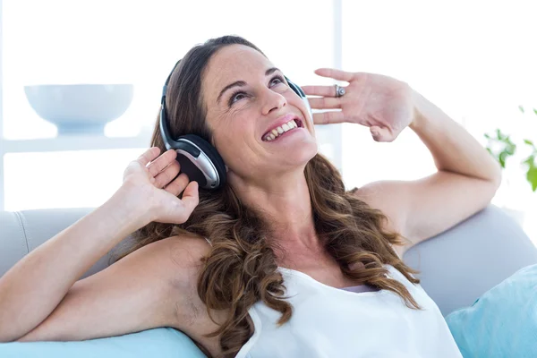 Lachende vrouw luisteren muziek thuis — Stockfoto