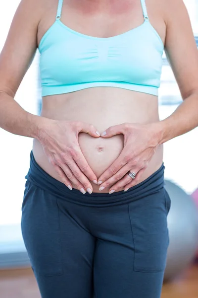 Mulher grávida fazendo forma de coração — Fotografia de Stock