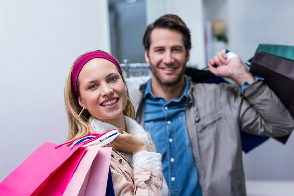 Lachende paar met shopping tassen — Stockfoto