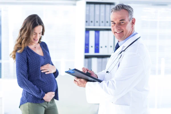 Klinik hamile kadın ile erkek doktor — Stok fotoğraf
