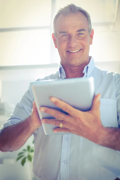 Hombre de negocios sonriente sosteniendo tableta digital — Foto de Stock