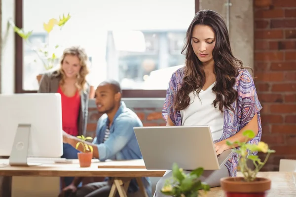 Empresária usando laptop no escritório — Fotografia de Stock