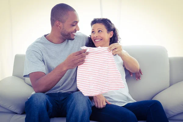Cheerful couple with baby clothing — Stock Photo, Image