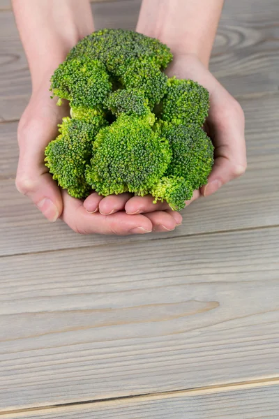 Mujer mostrando brocolli verde fresco — Foto de Stock