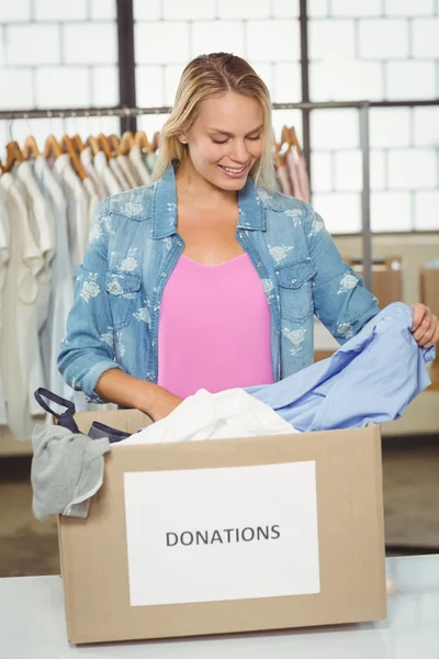 Mujer separando la ropa de la caja de donación — Foto de Stock