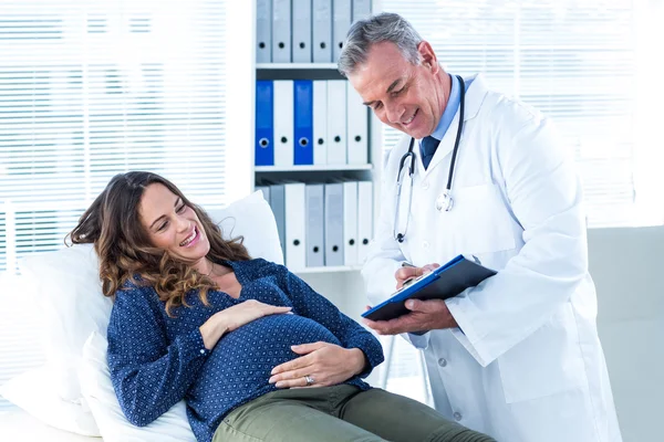 Hamile kadın doktor gösteren belgeye — Stok fotoğraf