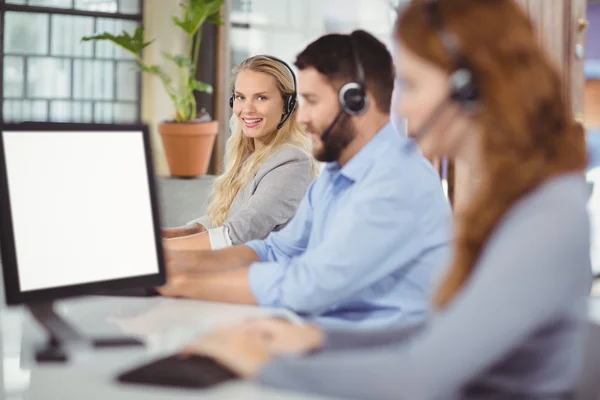 Smiling operator with colleagues — Stock Photo, Image