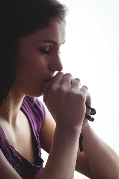 Donna che prega con perline di legno rosario — Foto Stock