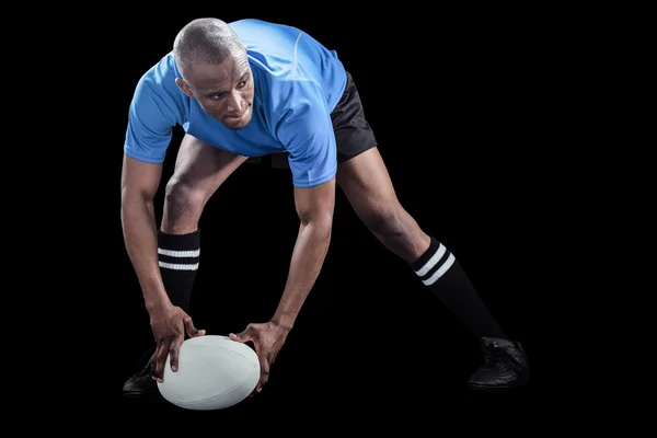 Sportovec, ohýbání a držení míče — Stock fotografie