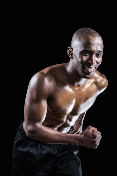 Muscular man smiling while running — Stock Photo, Image