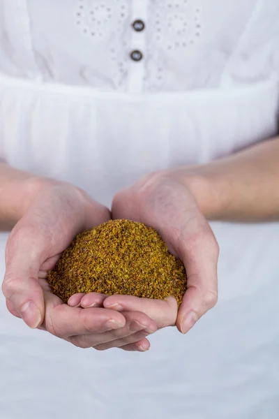 Woman showing handful of milled seed — Stock Photo, Image