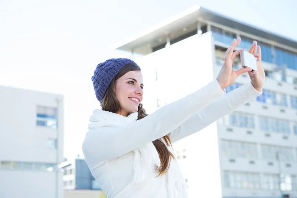 Brunette with warm clothes taking selfie — Stock Photo, Image