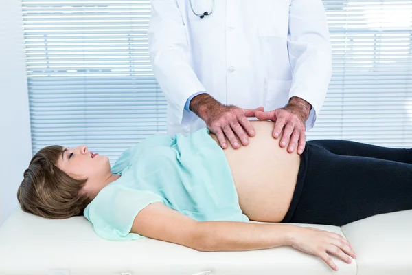 Doktor dotýká břicho těhotné ženy — Stock fotografie
