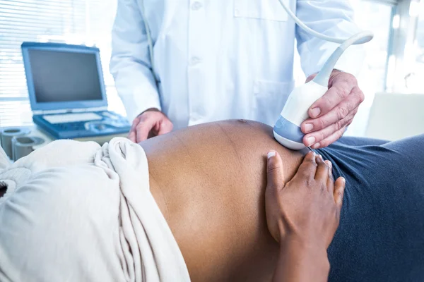 Doctor performing ultrasound on pregnant woman — Stock Photo, Image