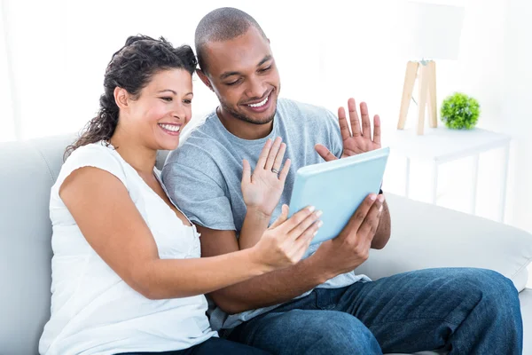 Happy couple waving at tablet — Stock Photo, Image