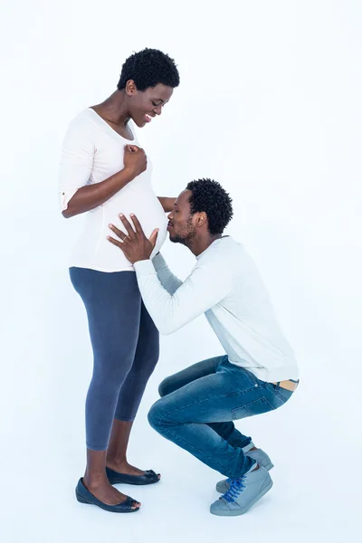 Affectionate man kissing belly of his wife — Stock Photo, Image