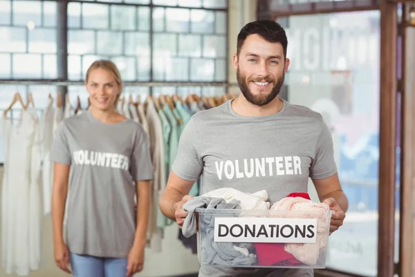 Wolontariuszy gospodarstwa ubrania darowiznę pole — Zdjęcie stockowe