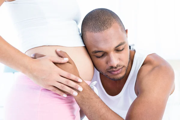 Homem ouvindo barriga de esposa grávida — Fotografia de Stock