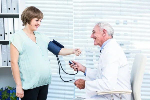 Médico revisando presión arterial — Foto de Stock